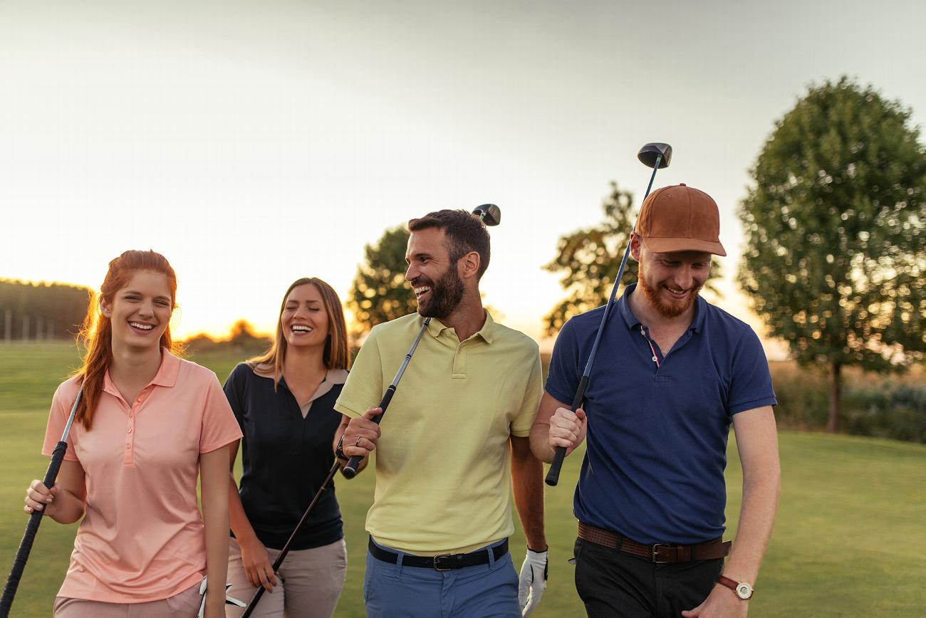 Group of friends smiling holding golf clubs