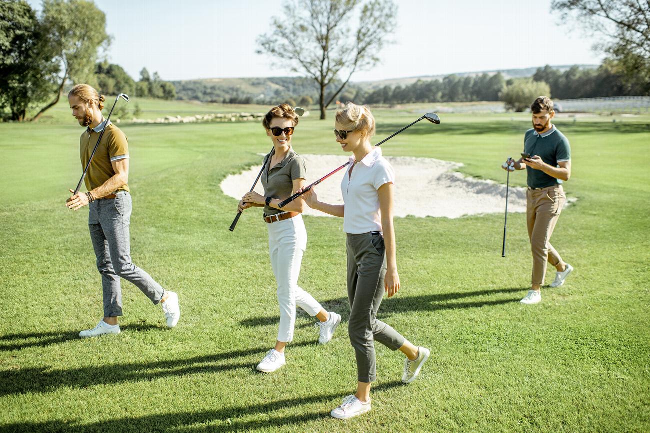 Well dressed group of friends walking playing golf